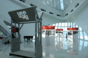 Picture of a building with a stand with a angled plate showing "USG"